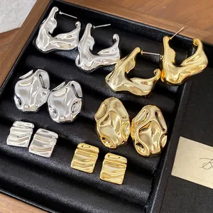 Eleganti orecchini in metallo testurizzato oro e argento in una scatola di velluto nero