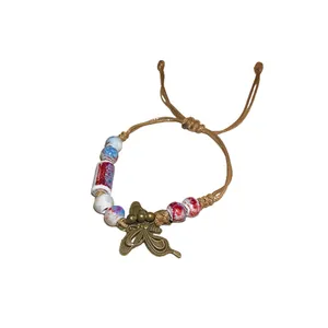 Vintage ethnic style woven bracelet with ceramic beads and a bronze butterfly charm