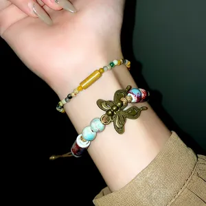 Close-up of vintage butterfly ceramic beaded bracelet with ethnic woven rope