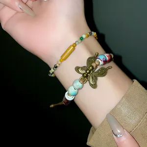 Detailed close-up view of retro ethnic style ceramic bead bracelet with butterfly charm