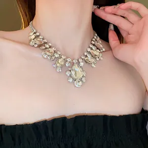 Detailed close-up of a sparkling silver rhinestone statement necklace worn by a model