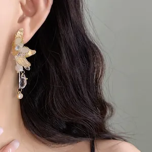 Primo piano di un elegante orecchino a farfalla dorato con cristalli scintillanti