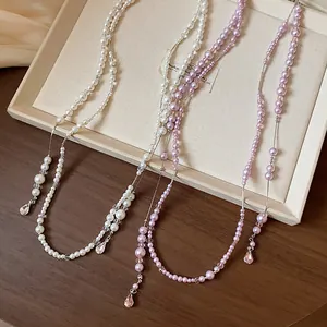 Detail of French style long beaded pearl necklaces with crystal teardrop pendants