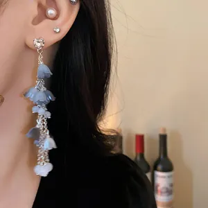 Vue détaillée de boucles d'oreilles élégantes en argent avec fleurs à pampilles bleues et strass