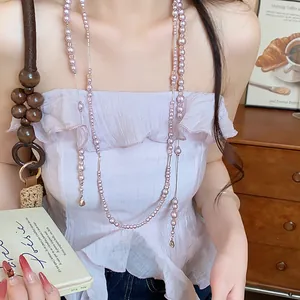 Close-up of elegant long pink pearl necklace with crystal accents on a model
