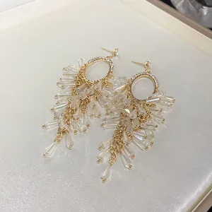 Detailed shot of elegant gold-toned crystal tassel earrings with sparkling oval rhinestone accents