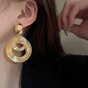 Primo piano dettagliato dei raffinati orecchini a cerchi concentrici in filo d'oro