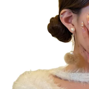 Elegant gold-plated pearl drop earrings featuring a brown fur ball and zircon on model