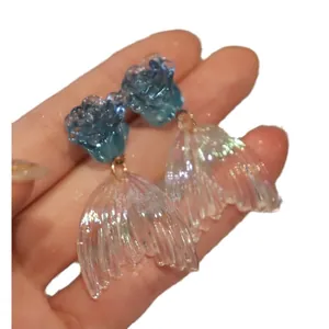 Hand-held elegant mermaid tail drop earrings with blue resin rose and iridescent finish
