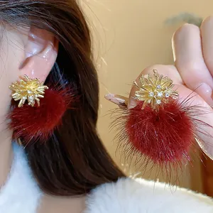 Close-up of elegant firework earrings with red fur balls and sparkling rhinestones