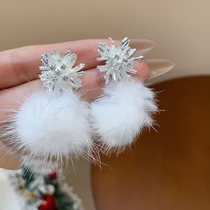 Close-up of elegant firework stud earrings with white fluffy pom poms and rhinestones