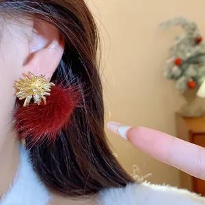 Detailed macro view of firework gold stud earring with burgundy faux fur pom-pom