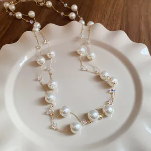 Close-up detail of a double-strand necklace featuring elegant pearls and glass beads