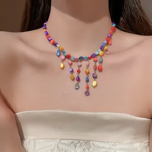 Elegant bohemian style necklace with colorful irregular glass beads worn by a model