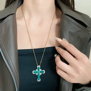 Detaillierte Makroansicht einer eleganten grünen Zirkon-Kreuz-Halskette an Goldkette