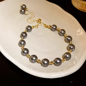 Scatto dettagliato di alta qualità di un bracciale di perle grigie su un vassoio di ceramica