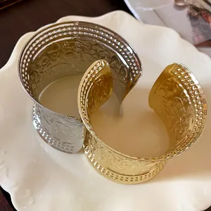 Detail view of vintage style gold and silver metal cuff bracelets with intricate patterns