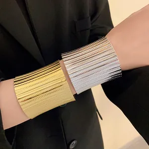 Close-up of textured gold and silver metal wide open cuff bracelets for women