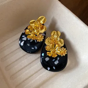 Vintage gold floral metal earrings with black oval resin marble effect stud design