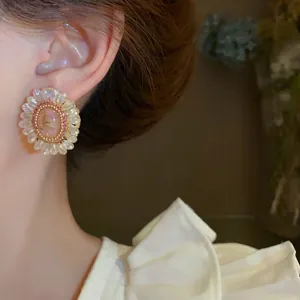 Eleganti orecchini a lobo a fiore di cristallo con aghi d'argento, indossati da una modella