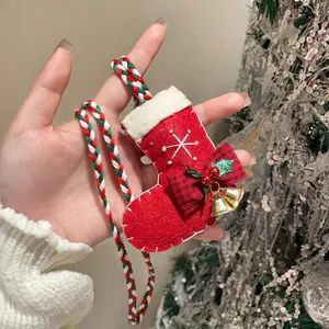 Detailed view of a festive red felt Christmas stocking pendant on a braided cord