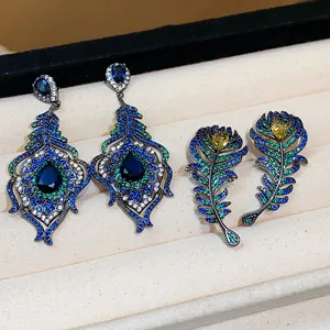 Close-up detail of peacock feather earrings featuring vibrant blue and yellow zircons