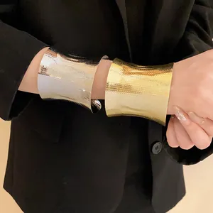 Detailed view of gold and silver hammered metal wide cuff bracelets