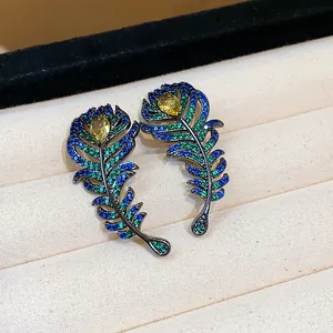 Detailed shot of vintage feather stud earrings with colorful zircons in dark setting