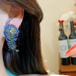 Vintage French style peacock feather zircon stud earrings worn on ear for elegant look