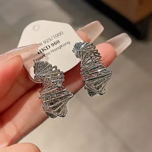 Detailed macro view of irregular geometric silver earrings with a unique twisted design
