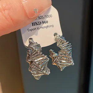 Macro detail of irregular silver-colored wire-wrapped design hoop earrings