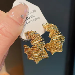 Detailed close-up of gold-plated irregular geometric wire-wrapped hoop earrings design