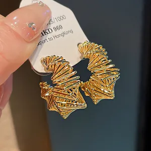 Detailed view of gold-plated geometric hoop earrings with intricate wire-wrapped design