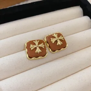Macro view of vintage French Maillard brown floral stud earrings with gold accents