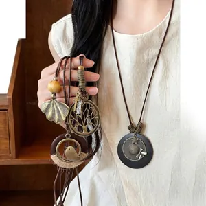 Macro view of vintage Bohemian long necklaces with tree and leaf pendants