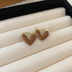 Close-up macro detail of retro Maillard brown heart earrings with elegant gold trim