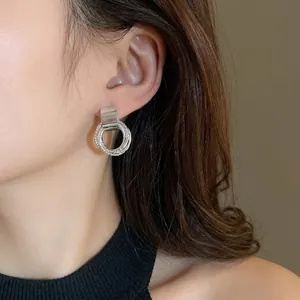 Orecchini a cerchio geometrici in metallo argentato da donna dal design minimalista.