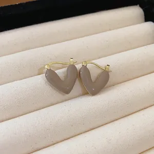 Close-up of French vintage heart earrings in coffee color enamel on jewelry tray.