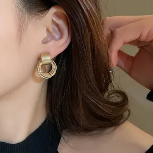 Eleganti orecchini a cerchio geometrici dorati con anelli multistrato per un look minimalista.