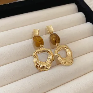 Detail of French retro gold earrings with amber resin beads in a jewelry tray