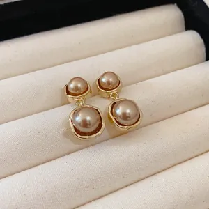 Detail shot of vintage French style pearl drop earrings in warm Maillard brown tone