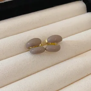 Detail of French vintage Maillard coffee-colored glossy enamel stud earrings in a jewelry box