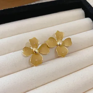 Macro view of French vintage style coffee-colored flower earrings in a velvet jewelry box