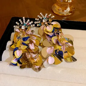 Statement sequin dangle earrings with colorful rhinestones on a jewelry display tray.