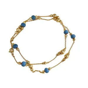 Vintage gold-tone jewelry set featuring a double-strand design with elegant blue beads
