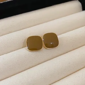 Detailed view of vintage coffee brown enamel square stud earrings with elegant gold trim