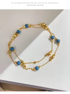 Detail shot of vintage style necklace featuring blue beads and textured gold ball beads