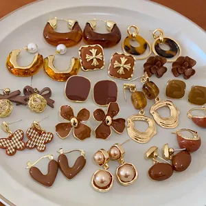 Detailed view of various Maillard brown earrings featuring retro floral and pearl designs.