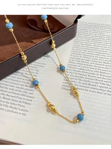 Close-up detail of vintage gold chain necklace with blue and textured gold beads