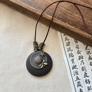 Detail view of the vintage Zen-style necklace with hat pendant and bronze accents